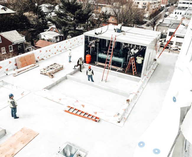 aerial view of men working on mechanical penthouse on roof of BU theatre